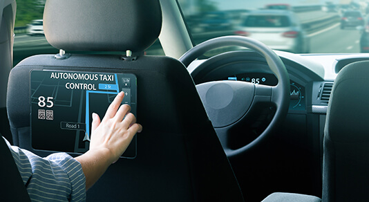 Passenger sitting in the backseat and selects a route when autonomous taxi rides on the highway.