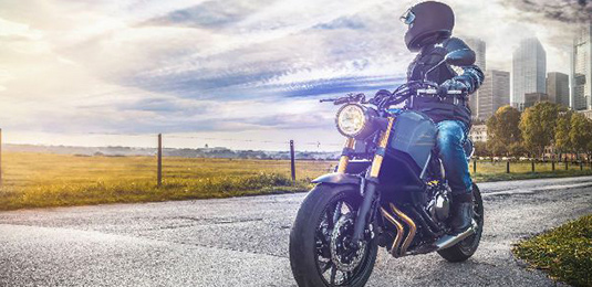 A man on his motor cycle watching the sky